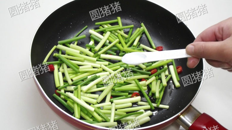 腊肠炒蒜苔,锅内剩下的油,放入蒜苔及盐1/4小匙,中火炒至蒜苔表皮有些微起皱即熟。