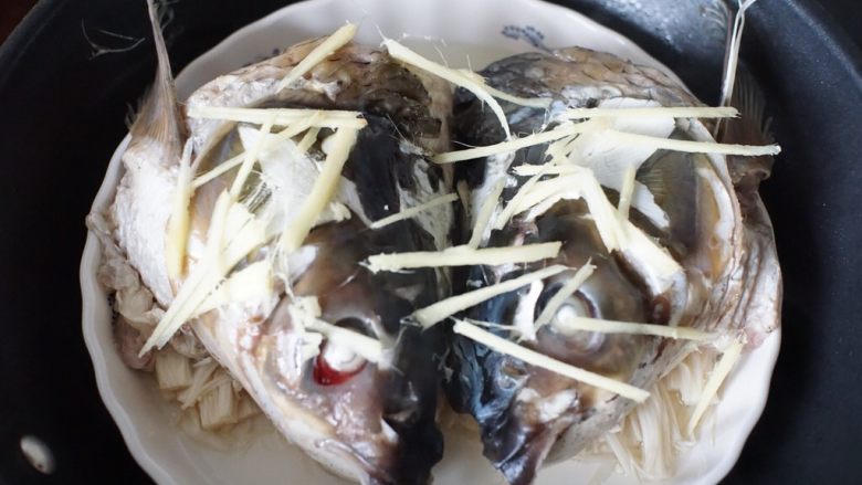 十味 剁椒鱼头,金针菇蒸软后放入鱼头,在鱼头表面铺上姜丝,盖上锅盖蒸8分钟