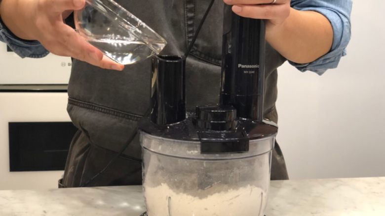 南瓜炖饭万圣节派,先倒入一半的冰水 也是间断打碎
这个时候面粉粒会比较细碎一点 再倒入剩下的冰水打碎