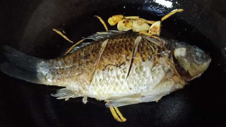 十味 奶白鲫鱼豆腐汤,6、煎到一面金黄翻另外一面继续煎