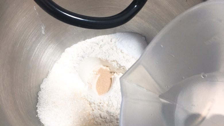 奶酥花色面包,清水加温37度左右,倒入厨师机桶内,搅拌一下。