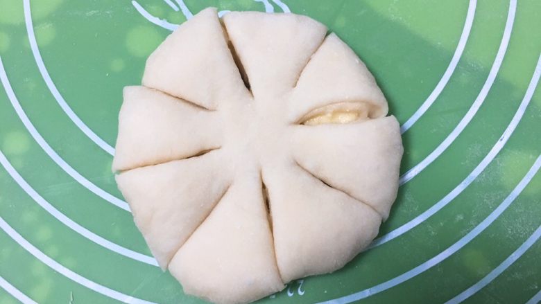 奶酥花色面包,将剂子再擀成圆饼,用刀切八刀,中间留出一点。