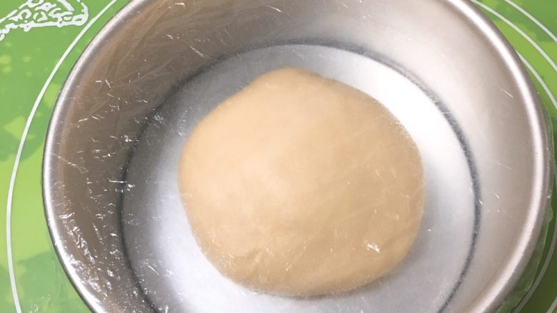 奶酥花色面包,滚圆,盖上保鲜膜放入模具中。