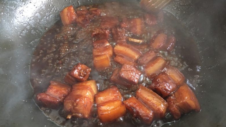 红烧肉,等到汤汁浓稠变少后转大火收汁,不断翻炒,颜色也越来越浓,此时可根据口味加少许盐不加也可