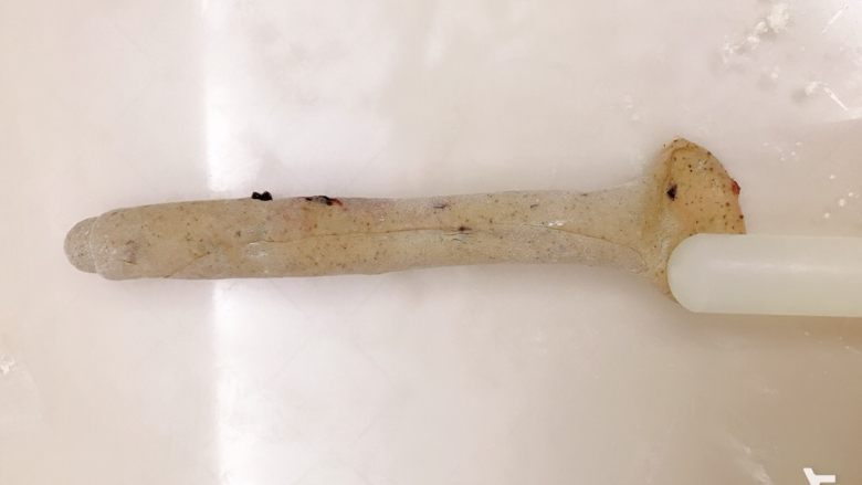 红茶蓝莓贝果,接缝处朝上,一头用擀面杖擀开
