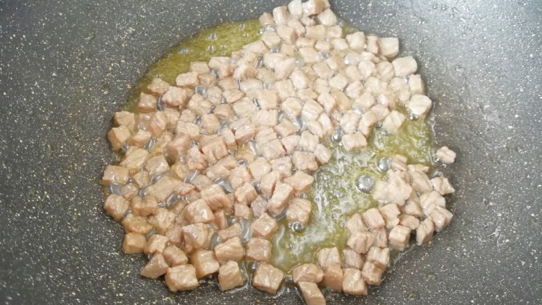 咖喱牛排炒饭,炒锅烧热倒入适量的食用油,下入牛排丁翻炒至熟,盛出备用。
