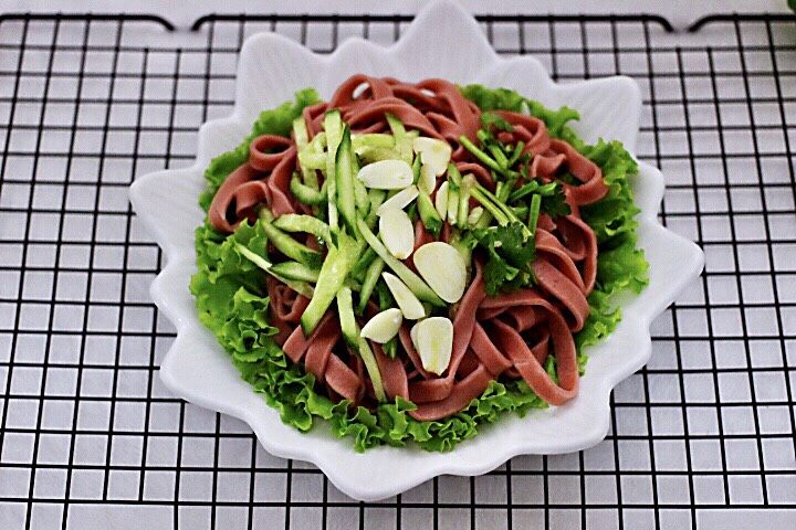 十味 美味油泼面,面条上放入黄瓜丝,蒜片和香菜段
