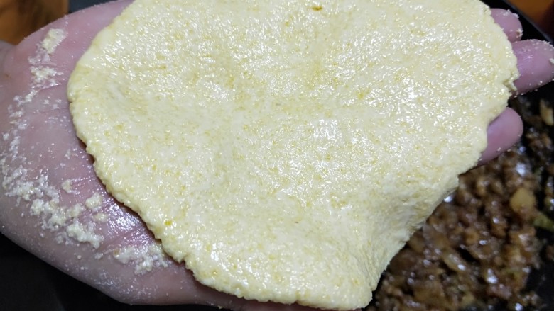 新文美食 红萝卜灯玉米团子,取一个面团用手压扁。