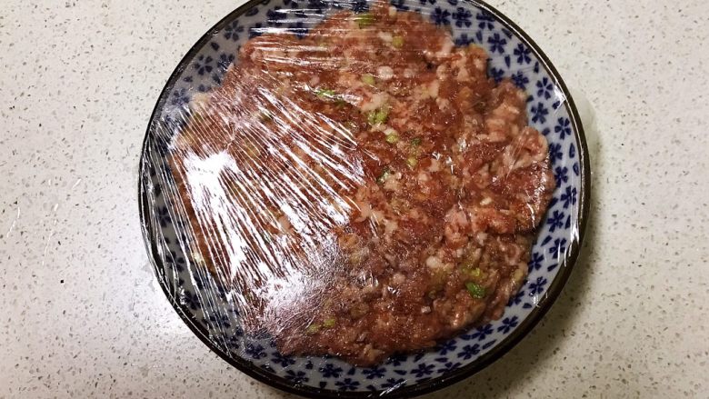 番茄汁焗茄盒,把调好的肉馅放入盘里,盖上保鲜膜,静止入味15分钟