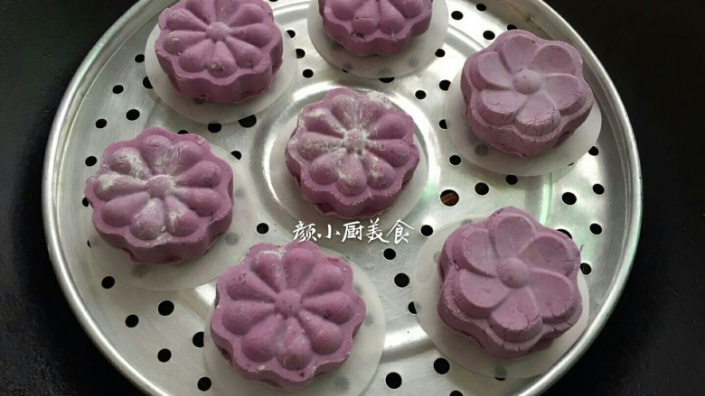 紫薯饼,全部做好的紫薯饼底部垫一张糕点纸放入蒸架下锅蒸,大火蒸至紫薯饼熟透,蒸至紫薯饼有点微涨即熟透了,即可关火