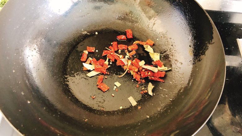 香甜辣味虾-年夜饭、宴请菜,把刚才炸虾的油倒去,留少许在锅中,开大火,倒入辣椒、香叶、花椒炒香。