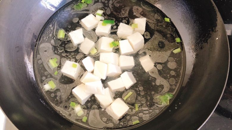 豆腐花哈汤,放入豆腐块,盖上锅盖。