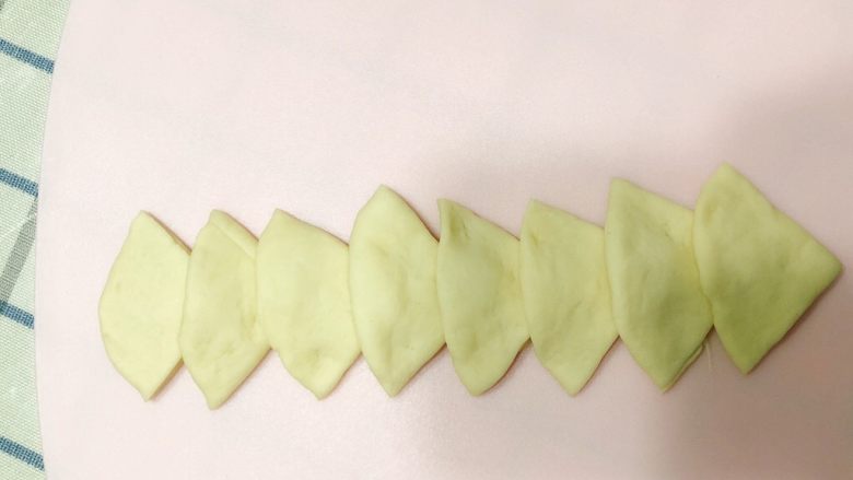 花样馒头-兔子、玫瑰形状,将8片三角形一个接一个叠放整齐,并用手压实,使他们粘连在一起。