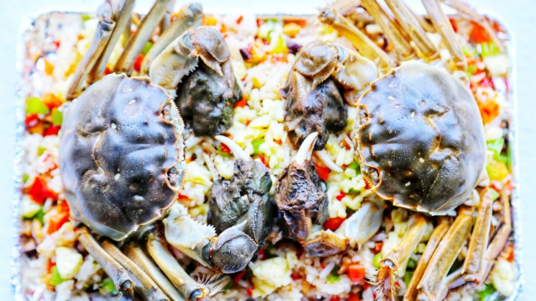 美食丨膏蟹焗饭 鲜香弥漫 垂涎何止三尺!,把处理好的大闸蟹放在炒饭上,肚子那边朝下。