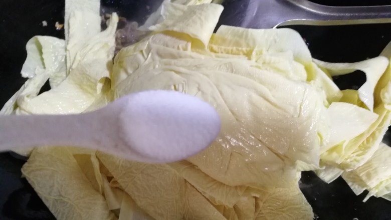 牛肉丝炒油豆皮,然后放入油豆皮儿,再放入一勺盐炒几下。小火