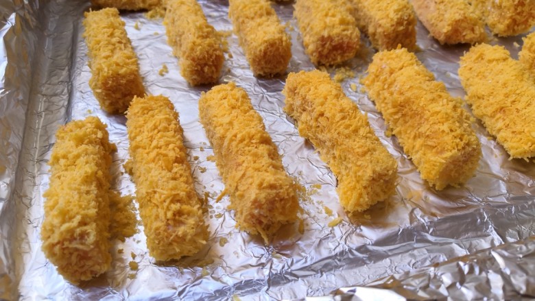 十味 香酥南瓜条,把裹好面包糠的南瓜条,放在刷有油的锡纸上。