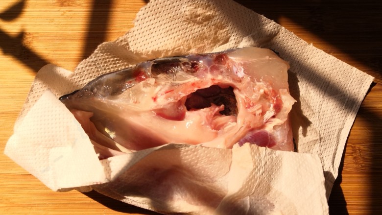 十味 鱼头豆腐汤,把腌制好的鱼头用清水多冲洗几次,用厨房纸把表面水份擦干。
