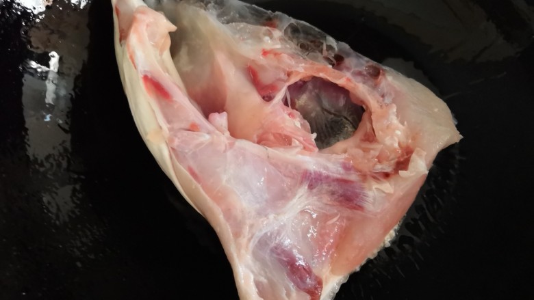 十味 鱼头豆腐汤,锅里加入几片姜爆香捞出,放入鱼头。