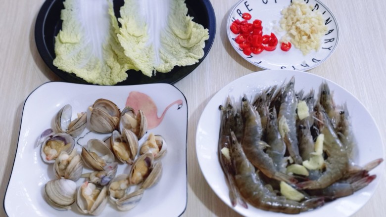 15分钟get惊艳大餐~烤海鲜,蒜去皮切碎,辣椒去根切碎,<a style='color:red;display:inline-block;' href='/shicai/ 140'>娃娃菜</a>洗干净放烤盘中。(辣椒的量可以根据个人口味增减)