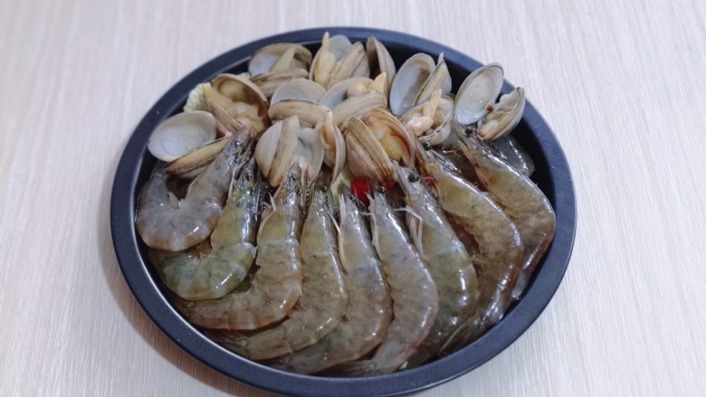 15分钟get惊艳大餐~烤海鲜,将煮开口的蛤蜊摆放在上面,腌制好的虾摆放在下面!