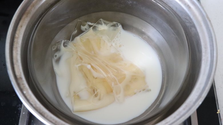 预热万圣节,KT也来凑热闹,双色巧克力慕斯,准备巧克力层的材料。吉利丁片在冷水中泡软。放入<a style='color:red;display:inline-block;' href='/shicai/ 219'><a style='color:red;display:inline-block;' href='/shicai/ 219'>牛奶</a></a>中,隔热水融化,温度不可过高,40-50度即可。