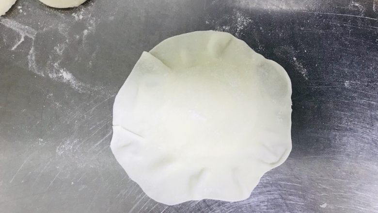 猪肉糯米烧麦,擀成饺子皮厚度,然后再用擀面棍把边缘部分擀薄。