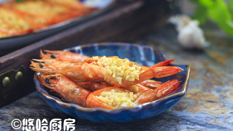 烤蒜蓉开背虾,烘烤结束后取出烤盘,烤好的虾装盘,要趁热吃才香。