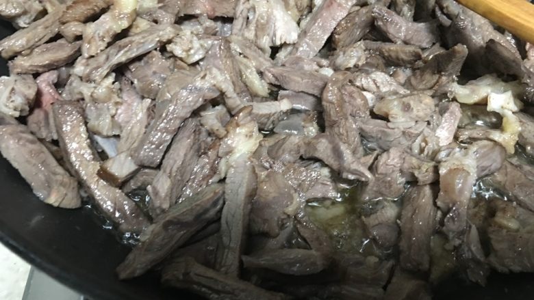 麻辣牛肉干,牛肉丝开始变深色的时候加入盐继续翻炒、搅匀,盐一定要提前加入,才能入味。