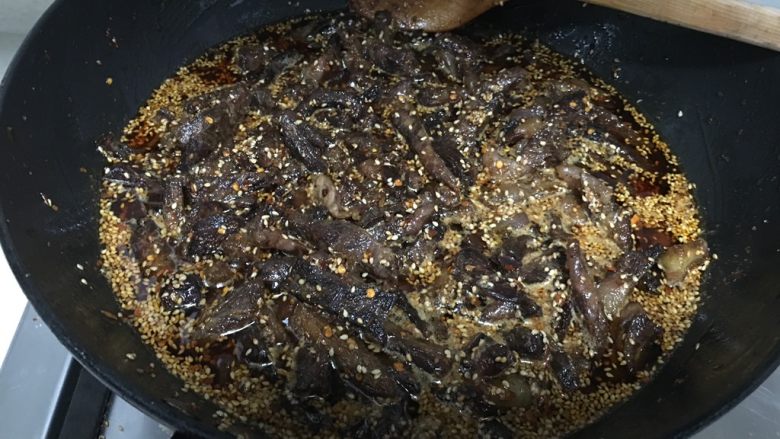 麻辣牛肉干,夜晚灯光影响,照片上炒熟的牛肉干看起来颜色很深。