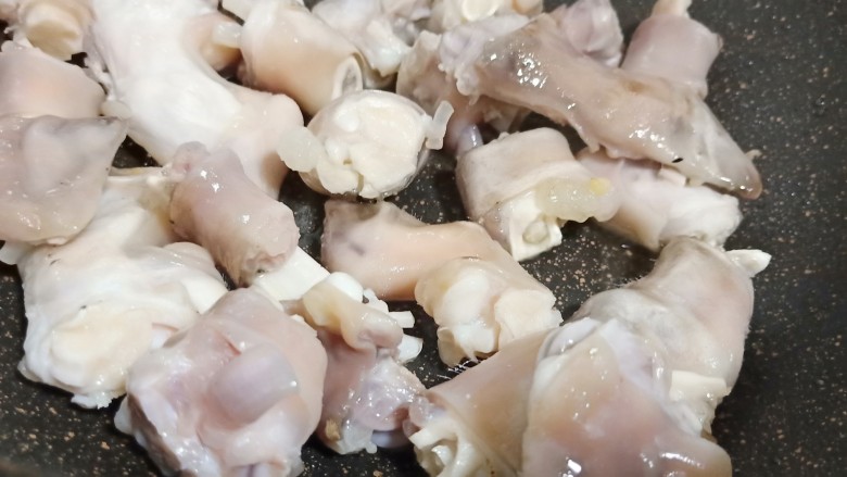 秋冬养生滋补《白果焖羊蹄》,锅里加适量的油、加生姜片少许,油温五成热下羊蹄翻炒至表皮微黄。