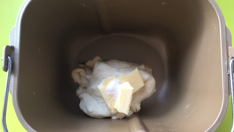 双色牛角酥,面团揉好后,加入黄油跟盐,继续启动揉面程序,将材料揉均匀