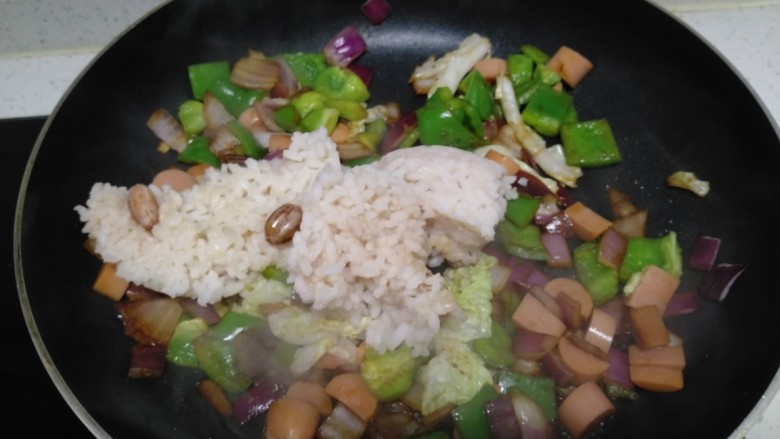 菜椒火腿炒米,翻炒均匀,倒入大米。