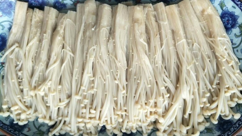 这道菜简单好吃,具有促进儿童智力发育的功能。,将煮好的金针菇捞出过水摆入盘中备用。