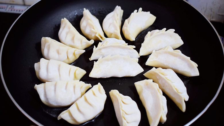 煎猪肉玉米饺子,锅中倒入适量的食用油,放入饺子