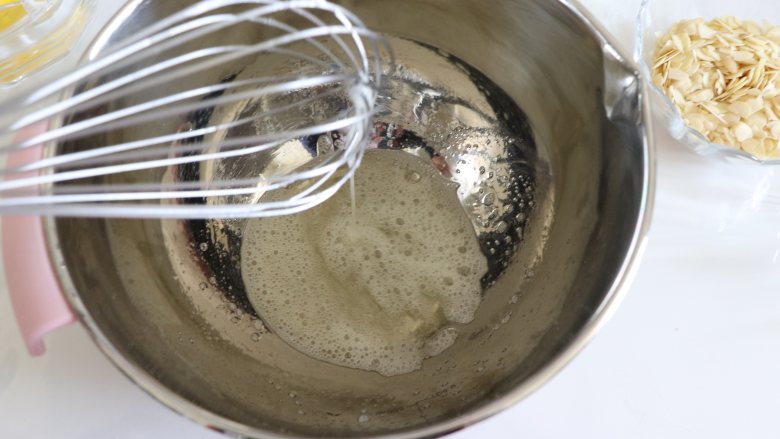 蔓越莓杏仁脆饼,简单制作营养美味小零食,用手动打蛋器,搅打均匀,糖融化,不要打发蛋白。
