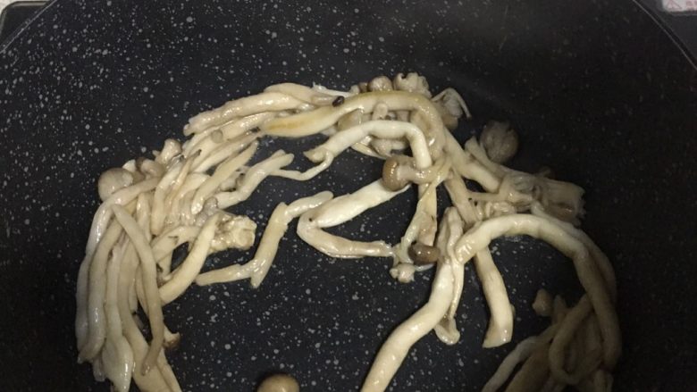 海鲜菇滑蛋,3️⃣ 油锅烧热,放入海鲜菇煸炒至微干。(海鲜菇一开始会炒出水分来,别急再接着炒至无水即可)