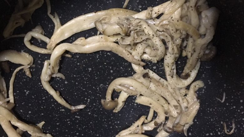 海鲜菇滑蛋,4️⃣ 大致变成这样以后撒入适量黑胡椒粒,翻炒均匀。