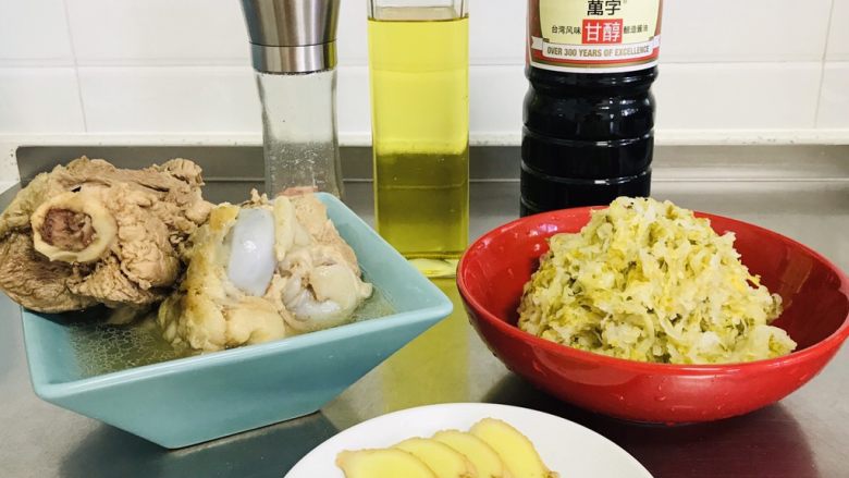 东北大骨头炖酸菜,所有材料准备齐全。做这道菜,大骨头老汤要提前煲出来。这里简单介绍一下,猪骨棒一根、鸡骨架一个清洗干净汆水,用电饭锅煲汤功能,煲了两个小时。