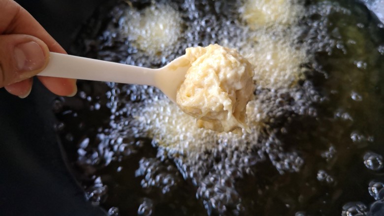 酥炸鱼翅南瓜丸子,锅中宽油,烧至5成热,用小勺子挖一勺厚糊成丸子状下入油锅。