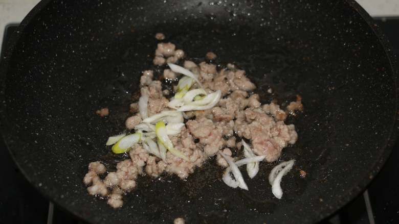 百财福袋,肉末变色后,放入葱花煸香。
