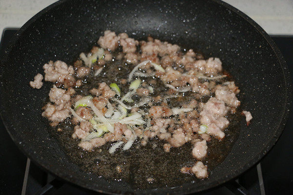 香菇糯米烧麦,锅内倒入适量食用油,煸香葱花,放入猪肉馅翻炒。