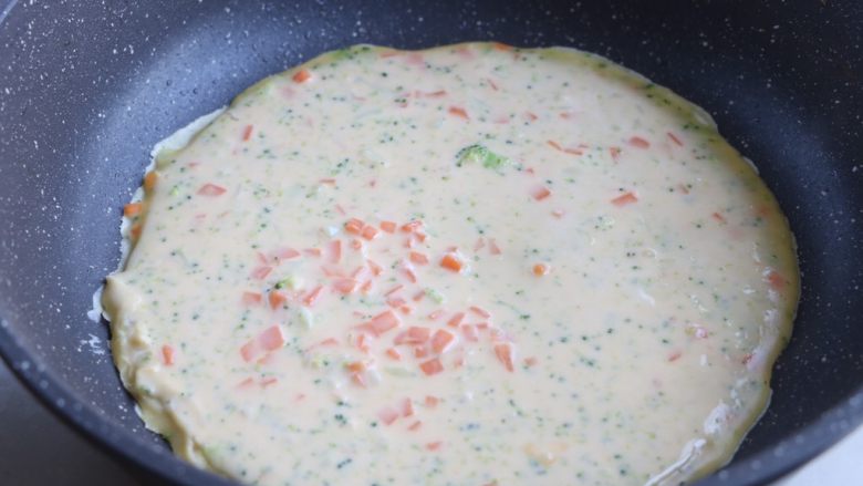 西兰花鸡蛋饼,平底锅刷一层植物油,倒入适量面糊使之铺满整个锅底;