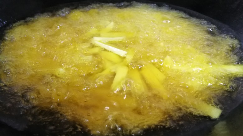 家常菜#牛肉炒蒜苗土豆#,锅添油烧9分熟,放入土豆条炸。