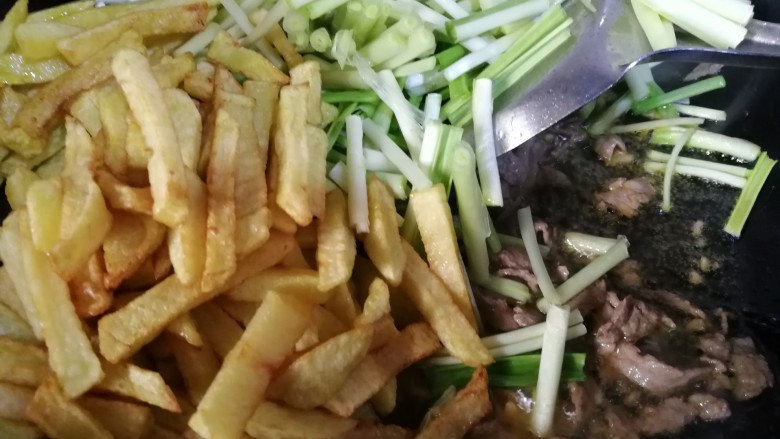 家常菜#牛肉炒蒜苗土豆#,牛肉炒熟,放入蒜苗,土豆条翻炒几下。
