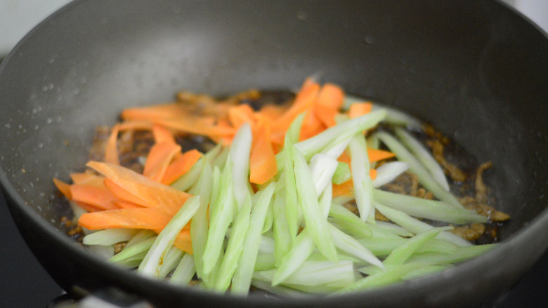 西芹胡萝卜肉丝,接着放入胡萝卜和西芹