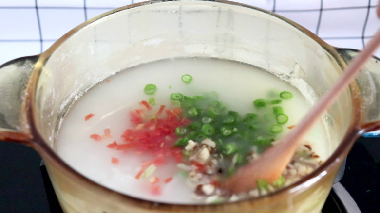 杂蔬肉松粥,大米煮至稍微软烂时,依次倒入胡萝卜丁,豆角丁,香菇丁