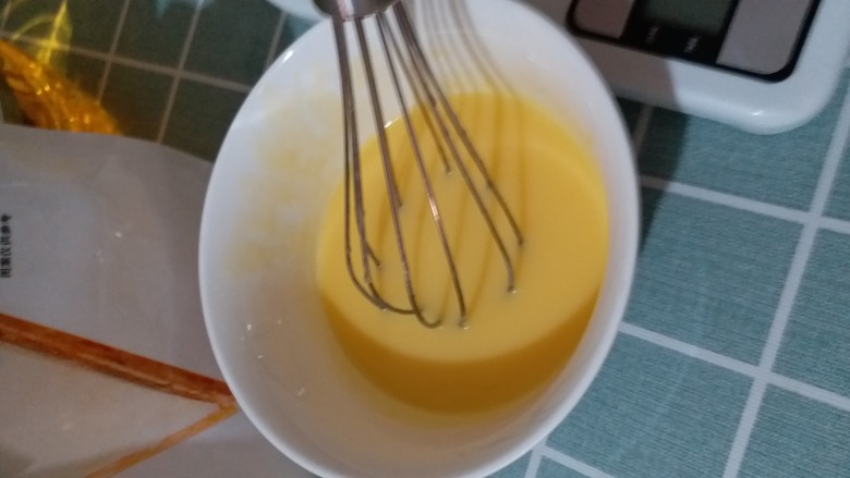果味戚风,加20g玉米油拌匀,这状态和刚才一样,只是变多了而已,此时加30g温水,如果水凉的话油会重新分离,如果真的油飘起来了要不停搅拌,尽量使其均匀。