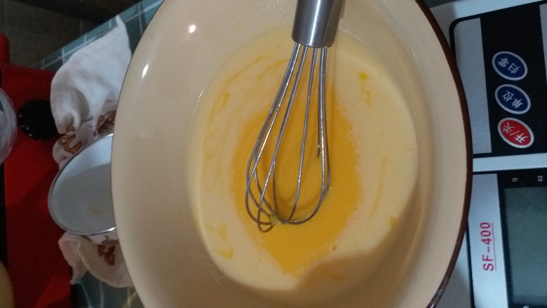 果味戚风,把这碗液体倒入装着四个蛋黄的盆里,不停搅拌,一边倒一边搅拌。
