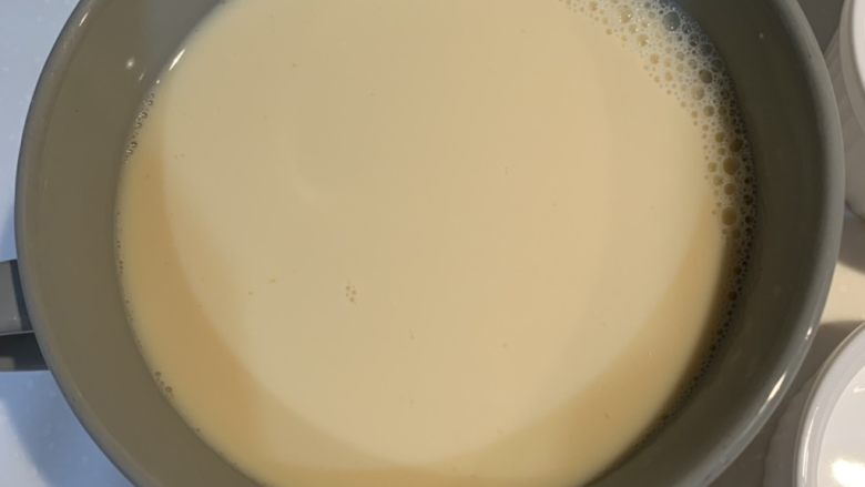 鸡蛋布丁,用过滤网,把搅拌好的蛋液和牛奶倒进一个碗里