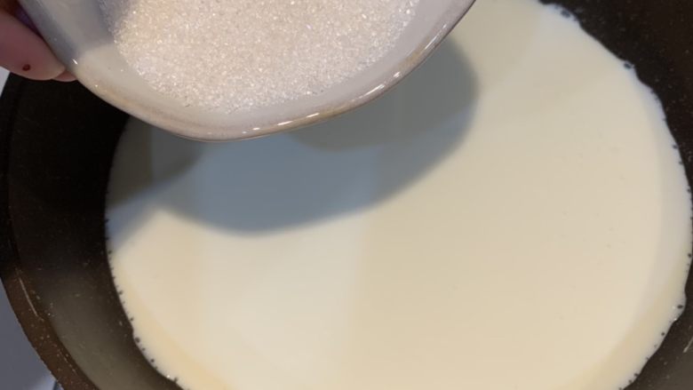鸡蛋布丁,牛奶入锅,煮到边缘冒小气泡关火,加入糖,搅拌至糖融化